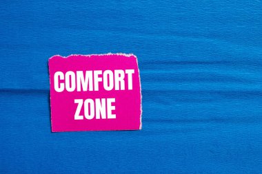 Comfort zone message written on ripped pink torn paper piece with blue background. Conceptual comfort zone symbol. Copy space. clipart