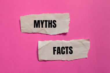 Efsaneler ve gerçekler pembe arkaplanlı yırtık kağıt parçalarına yazılmış. Kavramsal mitler ve gerçekler sembolü. Boşluğu kopyala.