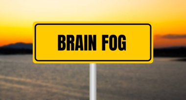 Bulanık göl arka planında sarı tabelaya yazılan beyin sisi mesajı. Kavramsal beyin sisi sembolü. Boşluğu kopyala.