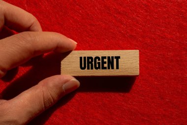 Ahşap bloğa kırmızı arka planlı acil mesaj. Kavramsal acil kelime sembolü. Boşluğu kopyala.