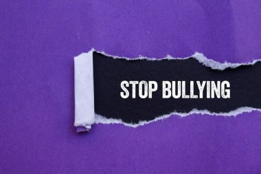 Siyah arka planda yırtık mor kağıda yazılmış mesajlara zorbalık etmeyi bırak. Kavramsal zorbalık sembolünü durdur. Boşluğu kopyala.