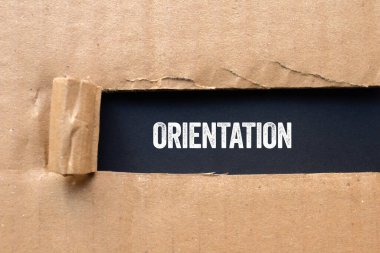 Siyah arka planda yırtık karton kağıda oryantasyon mesajı yazılmış. Kavramsal yönelim sembolü. Boşluğu kopyala.