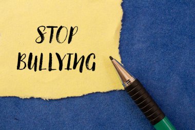 Mavi arka planda yırtık sarı kağıda yazılmış mesajlara sataşmayı bırak. Kavramsal zorbalık sembolünü durdur. Boşluğu kopyala.