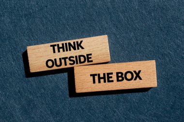 Gri arka plandaki tahta bloklara yazılmış kutu mesajının dışını düşün. Kutu sembolünün dışındaki kavramsal düşünce. Boşluğu kopyala.