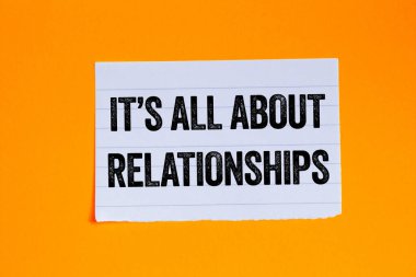 Turuncu arka plandaki yırtık beyaz kağıt parçasına yazılmış ilişki mesajlarıyla ilgili. Kavramsal her şey ilişkiler sembolüdür. Boşluğu kopyala.