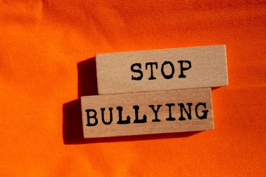 Turuncu arka planda tahta bloklara yazılan mesajlarla uğraşmayı bırak. Kavramsal zorbalık sembolünü durdur. Boşluğu kopyala.