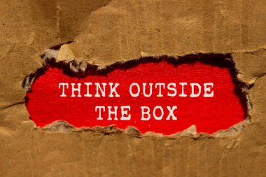 Kırmızı arka planda yırtık karton kağıda yazılmış kutu mesajı dışında düşünün. Kutu sembolünün dışındaki kavramsal düşünce. Boşluğu kopyala.