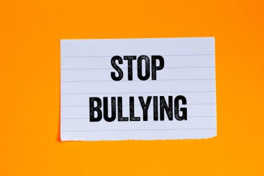 Turuncu arka plandaki yırtık beyaz kağıt parçasına yazılan mesajlara zorbalık etmeyi bırak. Kavramsal zorbalık sembolünü durdur. Boşluğu kopyala.