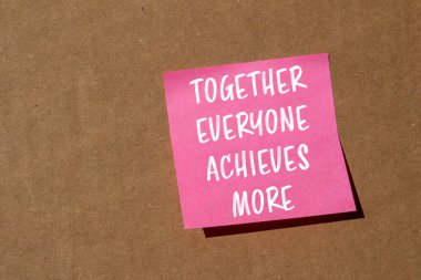 Birlikte herkes kahverengi arka planda pembe kağıda yazılmış daha fazla mesaja ulaşır. Kavramsal olarak herkes daha fazla sembol elde eder. Boşluğu kopyala.