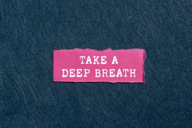 Gri arka planda yırtık pembe kağıt parçasına yazılmış derin bir nefes mesajı alın. Kavramsal bir nefes alma sembolü. Boşluğu kopyala.