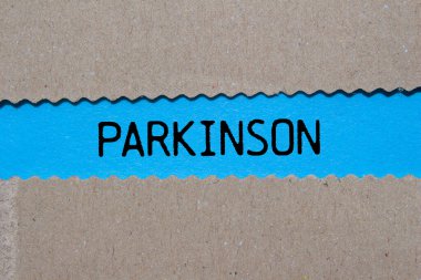 Parkinson mesajı mavi arka plandaki yırtık kağıda yazılmış. Kavramsal Parkinson sembolü. Boşluğu kopyala.