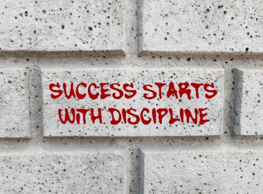Başarı, gri taş duvara yazılmış disiplin mesajıyla başlar. Kavramsal başarı disiplin sembolüyle başlar. Boşluğu kopyala.