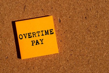 Kahverengi arka planda turuncu kağıda fazla mesai ödemesi mesajı yazılmış. Kavramsal fazla mesai ödeme sembolü. Boşluğu kopyala.