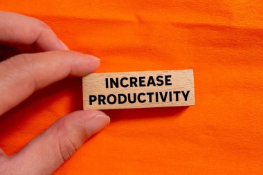 Turuncu arka plandaki ahşap blokta yazılan verimlilik mesajını arttır. Kavramsal üretkenlik sembolü. Boşluğu kopyala.