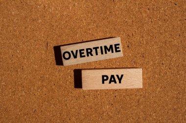 Kahverengi arka plandaki tahta bloklara fazla mesai ödemesi mesajı. Kavramsal fazla mesai ödeme sembolü. Boşluğu kopyala.