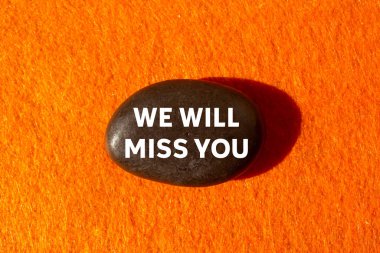 Turuncu arka planda siyah taşa yazdığın mesajı özleyeceğiz. Kavramsal olarak senin sembolünü özleyeceğiz. Boşluğu kopyala.