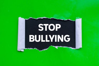 Siyah arka planda yırtık yeşil kağıda yazılan mesajlarla uğraşmayı bırak. Kavramsal zorbalık sembolünü durdur. Boşluğu kopyala.