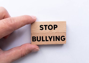 Beyaz arka planda tahta bloklara yazılmış mesajlara zorbalık etmeyi bırak. Kavramsal zorbalık sembolünü durdur. Boşluğu kopyala.