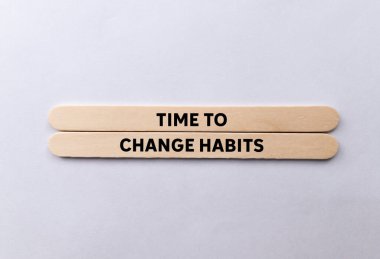 Beyaz arka planda tahta çubuklara yazılmış alışkanlıkları değiştirme zamanı. Alışkanlık sembolünü değiştirmek için kavramsal zaman. Boşluğu kopyala.