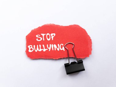 Beyaz arka plandaki yırtık kırmızı kağıt parçasına yazılan zorbalık mesajını durdurun. Kavramsal zorbalık sembolünü durdur. Boşluğu kopyala.