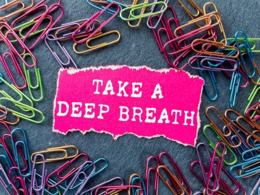 Gri arka planda yırtık pembe kağıt parçasına yazılmış derin bir nefes mesajı alın. Kavramsal bir nefes alma sembolü. Boşluğu kopyala.