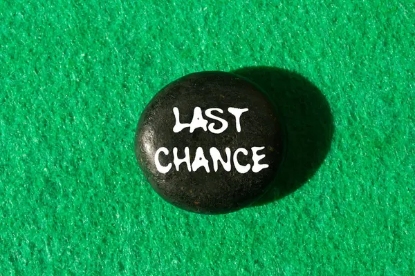 Yeşil arka planda siyah taşa yazılmış son şans mesajı. Kavramsal son şans sembolü. Boşluğu kopyala.