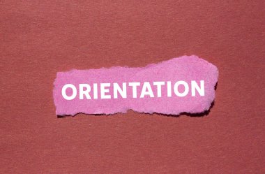 Kırmızı arka planda yırtık pembe kağıt parçasına oryantasyon mesajı yazılmış. Kavramsal yönelim sembolü. Boşluğu kopyala.