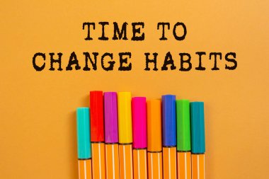 Turuncu arka planda yazılan alışkanlıkları değiştirme zamanı. Alışkanlık sembolünü değiştirmek için kavramsal zaman. Boşluğu kopyala.