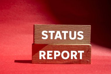 Kırmızı zemin üzerindeki tahta bloklara yazılmış durum raporu mesajı. Kavramsal durum raporu sembolü. Boşluğu kopyala.