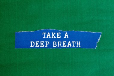 Yırtık mavi kağıdın üzerine yeşil arka planda yazılmış derin bir nefes mesajı alın. Kavramsal bir nefes alma sembolü. Boşluğu kopyala.