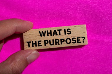 Ahşap blokta pembe arka planda ne yazıyor? Amaç sembolü nedir kavramsal olarak. Boşluğu kopyala.