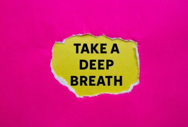 Sarı arka plandaki yırtık pembe kağıda yazılmış derin bir nefes mesajı alın. Kavramsal bir nefes alma sembolü. Boşluğu kopyala.