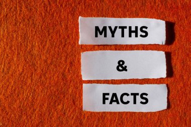 Efsaneler ve gerçekler turuncu arka plandaki yırtık beyaz kağıt parçalarına yazılmış. Kavramsal mitler ve gerçekler sembolü. Boşluğu kopyala.