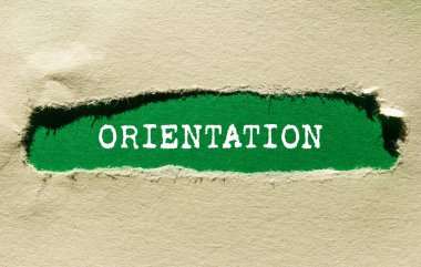 Yırtık kağıda yeşil arka planda oryantasyon mesajı yazıldı. Kavramsal yönelim sembolü. Boşluğu kopyala.