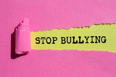 Sarı arka planda yırtık pembe kağıda yazılmış mesajlarla uğraşmayı bırak. Kavramsal zorbalık sembolünü durdur. Boşluğu kopyala.