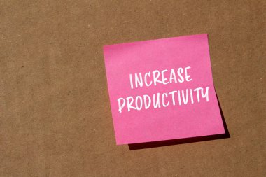 Kahverengi arkaplandaki pembe kağıda yazılan verimlilik mesajını çoğalt. Kavramsal üretkenlik sembolü. Boşluğu kopyala.