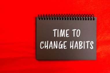 Kırmızı arkaplanda siyah defter sayfasına yazılan iletileri değiştirme zamanı. Alışkanlık sembolünü değiştirmek için kavramsal zaman. Boşluğu kopyala.