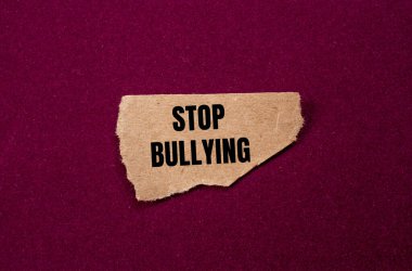 Mor arka planda yırtık kahverengi kağıt parçasına yazılan zorbalık mesajını durdurun. Kavramsal zorbalık sembolünü durdur. Boşluğu kopyala.