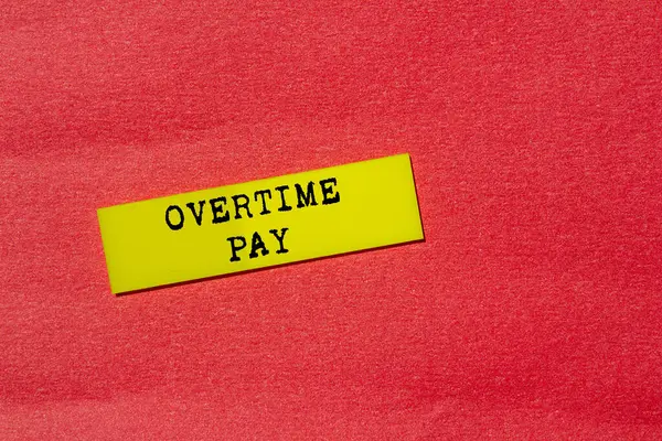Kırmızı arka planda sarı kağıt etikete fazla mesai ödemesi mesajı yazılmış. Kavramsal fazla mesai ödeme sembolü. Boşluğu kopyala.