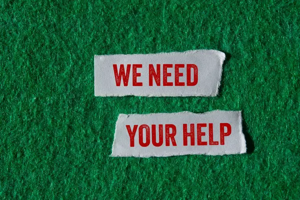 Yeşil arka planda yırtık kağıt parçalarına yazılmış yardım mesajına ihtiyacımız var. Kavramsal olarak yardım sembolüne ihtiyacımız var. Boşluğu kopyala.