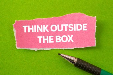 Yeşil arka plandaki yırtık pembe kağıt parçasına yazılmış kutu mesajının dışında düşün. Kutu sembolünün dışındaki kavramsal düşünce. Boşluğu kopyala.