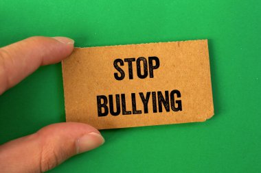 Yeşil arka planda karton kağıda yazılmış mesajlarla uğraşmayı bırak. Kavramsal zorbalık sembolünü durdur. Boşluğu kopyala.