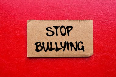 Kırmızı arka planda yırtık karton kağıt parçasına yazılmış mesajlara zorbalık etmeyi bırak. Kavramsal zorbalık sembolünü durdur. Boşluğu kopyala.