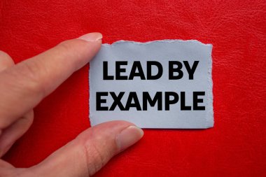 Kırmızı arkaplandaki yırtık gri kağıt parçasına yazılmış örnek mesajla. Örnek sembolle kavramsal liderlik. Boşluğu kopyala.