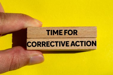 Sarı arka planda tahta bloklara yazılmış düzeltici eylem mesajı zamanı. Düzeltici eylem sembolü için kavramsal zaman. Boşluğu kopyala.