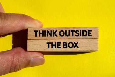 Sarı arka plandaki tahta bloklara yazılmış kutu mesajının dışını düşün. Kutu sembolünün dışındaki kavramsal düşünce. Boşluğu kopyala.