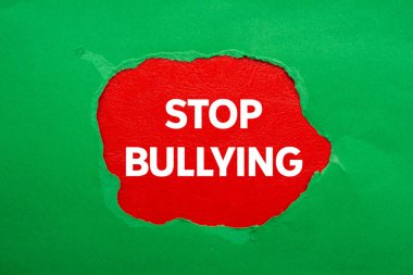 Kırmızı arka planda yırtık yeşil kağıda yazılan mesajlarla uğraşmayı bırak. Kavramsal zorbalık sembolünü durdur. Boşluğu kopyala.