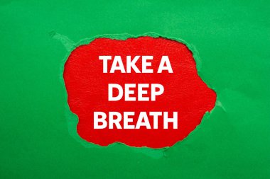 Kırmızı arka planda yırtık yeşil kağıda yazılmış derin bir nefes mesajı alın. Kavramsal bir nefes alma sembolü. Boşluğu kopyala.