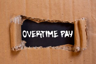 Siyah arka planda yırtık karton kağıda fazla mesai ödemesi mesajı yazılmış. Kavramsal fazla mesai ödeme sembolü. Boşluğu kopyala.