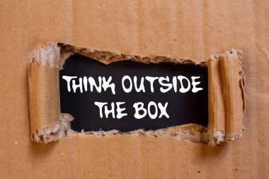 Siyah arka planda yırtık karton kağıda yazılmış kutu mesajı dışında düşünün. Kutu sembolünün dışındaki kavramsal düşünce. Boşluğu kopyala.